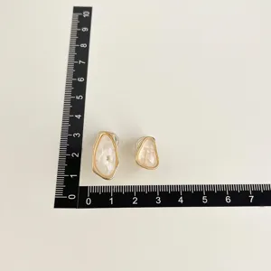 Schicke unregelmäßige geometrische Clip-Ohrringe mit weißer Muscheltextur und Goldrand.