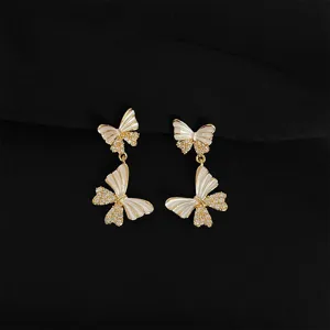 Elegante doppelte Schmetterling Ohrringe mit weissem Emaill und glitzernden Zirkonsteinen.