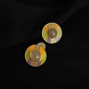 Vergoldete Ohrclips mit emaillierten geometrischen Mustern und transparentem Steindetail.