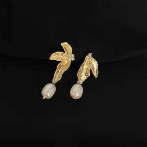 Nahaufnahme Details von eleganten goldenen Blatt- und Perlenohrringen, feine Handwerkskunst.