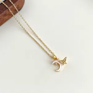 Detaillierte Nahaufnahme der vergoldeten Kette mit Perlmutt-Mond und Schmetterling Anhänger.