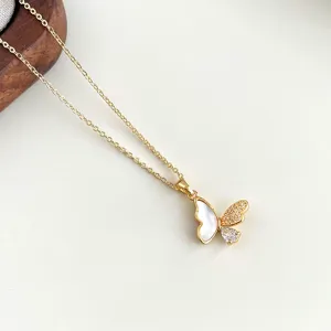 Detailaufnahme einer goldenen Schmetterlings-Halskette mit Perlmutt und Zirkonia Steinen.
