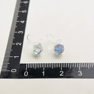 Detailed view of resin orb clip earrings with clear invisible coil design and silver metal mount.