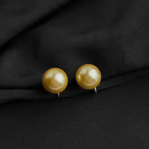 Goldene Perle Clip-On Ohrringe Detailaufnahme, elegante Ohrringe für Damen Schmuck.