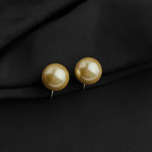 Detailansicht eleganter goldener Perlen-Clip-Ohrringe mit minimalistischem Spulen-Design.