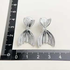 Detail shot of silver fish tail clip-on earrings with mosquito coil back, high quality design.