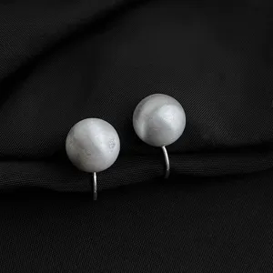Matte silberne Kugel Clip-Ohrringe minimalistischer Ohrschmuck Detailaufnahme elegant