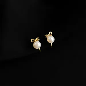 Elegante Perlen Ohrclips mit Schleife und vergoldetem Design für ungestochene Ohren.