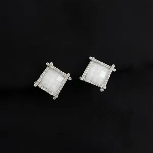 Closeup view of sparkling square pavé zircon ear clips showcasing delicate metal detailing.