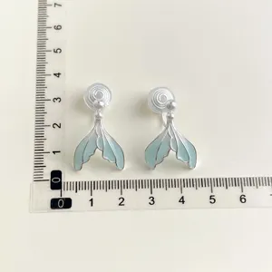 Detail shot of light blue mermaid tail clip-on earrings with pearl accent, non-pierced.