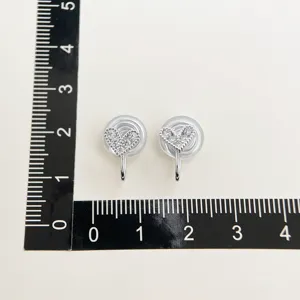 Detailed view of micro-paved zircon heart clip earrings with measurement scale for sizing.