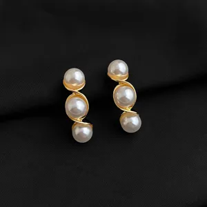 Detaillierte Nahaufnahme eleganter goldener Spiral-Mehrfach-Perlen-Ohrclips für Damen.