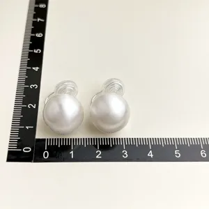 Detailansicht der Clip-Perlenohrringe mit transparenter Spule, gezeigt mit einer Größenskala.