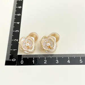 Vergoldete weiße Kamelien-Ohrclips mit Perlendetail und funkelnden Kristallen für Damen.