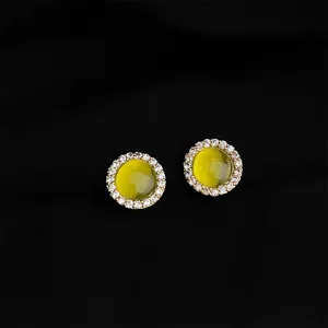 Eleganti orecchini rotondi con pietra gialla e scintillanti cristalli di zircone cubico.
