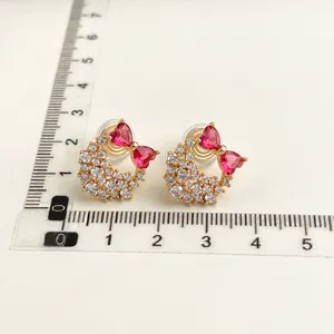 Vista dettagliata di orecchini a clip dorati con cristalli rosa a cuore e pavé di zirconi.