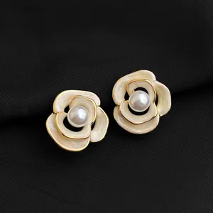 Nahaufnahme Detail von Luxus Kamelie Blumen Ohrclips mit Perlenmitte und Goldrand.