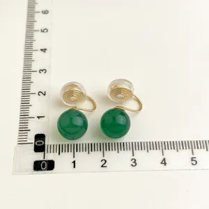 Vista dettagliata dell'orecchino clip con perla verde e righello per le dimensioni.