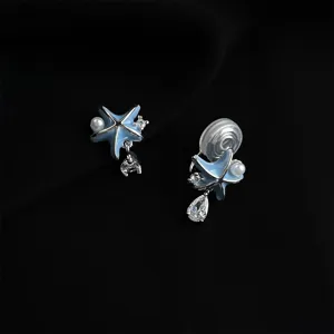 Close-up of blue starfish clip-on earrings featuring delicate pearls and sparkling rhinestones.