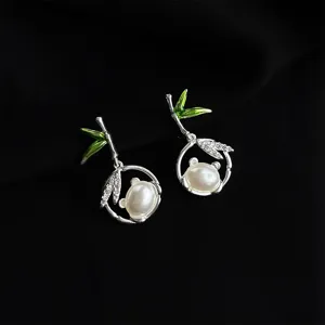 Exquisite bamboo pearl earrings for women, chic green enamel design and sparkling crystal detail.