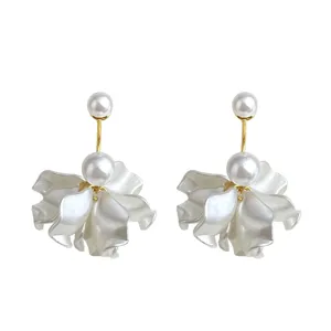 Closeup view of exquisite handmade floral earrings featuring double pearls and delicate gold details.