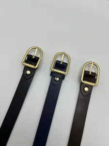 Dettaglio di una cintura da donna in ecopelle minimalista con fibbia ad ardiglione dorata.
