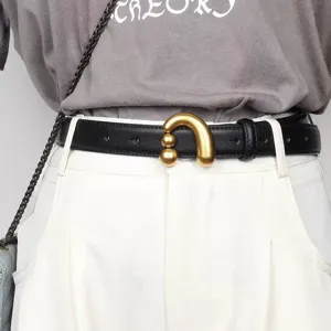 Gros plan détaillé de la ceinture en cuir PU noir élégant avec boucle sculpturale dorée.