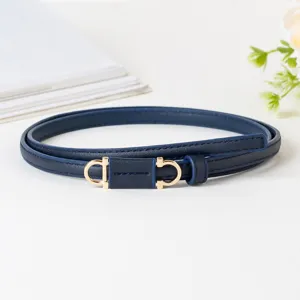 Detailopname van donkerblauwe smalle PU-lederen riem met gouden hoefijzervormige gesp als accent.