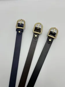 Dettaglio di cinture da donna minimaliste in pelle con fibbie metalliche dorate classiche.