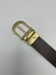 Gros plan sur la ceinture pour homme avec une boucle métallique dorée et une élégante lanière.