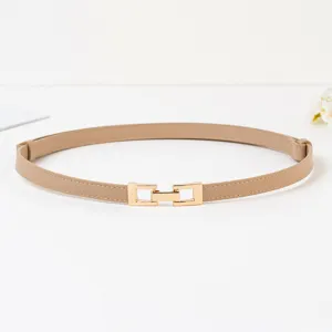 Détail de la fine ceinture pour femme avec boucle dorée minimaliste et lanière couleur kaki.