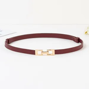 Vue de détail de la fine ceinture femme en cuir bordeaux avec boucle dorée, accessoire rétro.