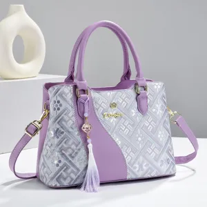 Elegant purple women handbag with geometric embroidery, top handle and crossbody strap.
