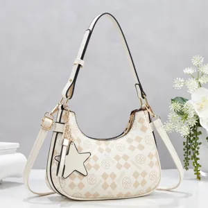 Close-up detail of the stylish beige hobo shoulder bag featuring monogram pattern and star charm.