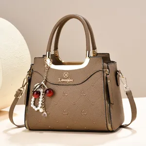 Elegant brown leather top-handle handbag with charming pearl cherry decor for daily commute.