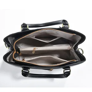 Detailed top view of black leather handbag interior, showing multi-compartment zip pockets.