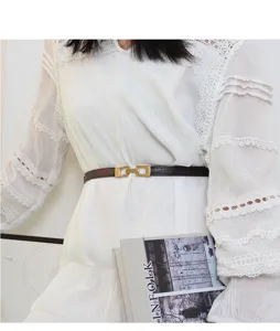 Ceinture fine en cuir pour femme avec boucle dorée, photo de détail idéale pour robes et manteaux.