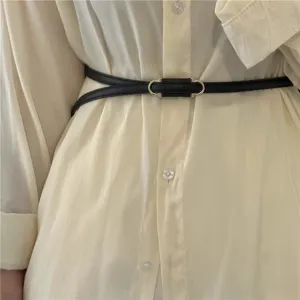Detailopname van dunne zwarte PU leren riem, elegant minimalistisch design voor dameskleding.