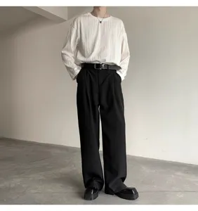 Detail view of stylish men's black pin buckle belt paired with casual business trousers.
