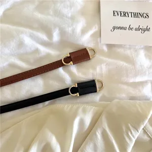 Detailopname van smalle PU-lederen riem met metalen gesp voor dames, minimalistisch accessoire.