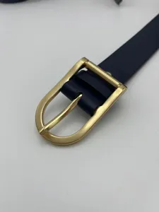 Close-up detail shot of the women's thin leather belt featuring a classic metal pin buckle.