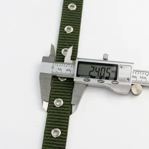 Vue détaillée de la largeur de la ceinture en toile de nylon verte, sangle avec œillets.