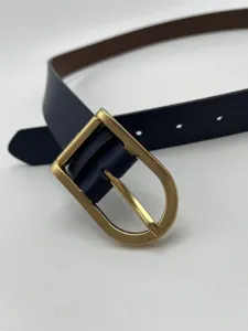 Close-up of women slim leather belt with vintage gold metal pin buckle elegant detail.