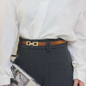 Ceinture fine et élégante en cuir marron avec boucle géométrique en métal doré.