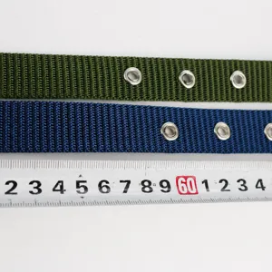 Gros plan montrant les détails des œillets de ceinture en toile et le ruban à mesurer.