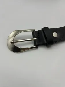 Vue détaillée d'une ceinture fine pour femme en noir avec boucle ardillon en métal argenté.