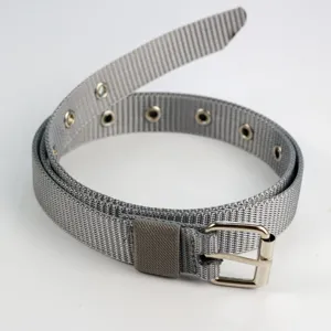 Gros plan détaillé de la ceinture fine en toile nylon grise avec œillets et boucle argentée.