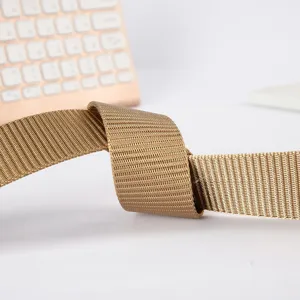 Close up detail of khaki nylon canvas belt webbing, durable textured fabric material.