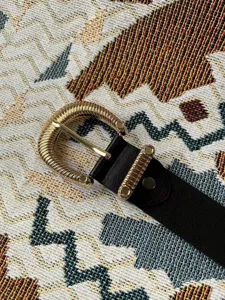 Elegante zwarte kunstlederen riem met een luxe getextureerde gouden metalen gesp.