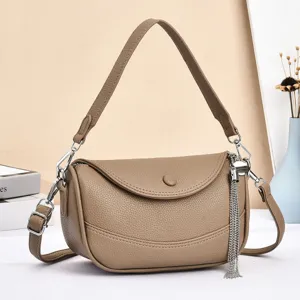Detailed view of stylish brown leather shoulder bag with chic metal tassel and strap design.